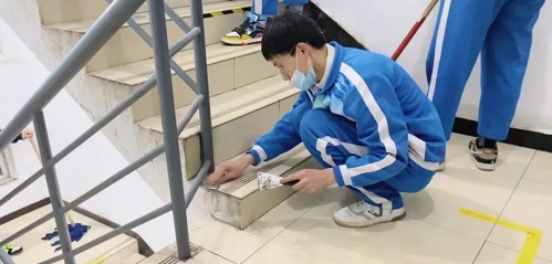 同学们认真清理垃圾死角